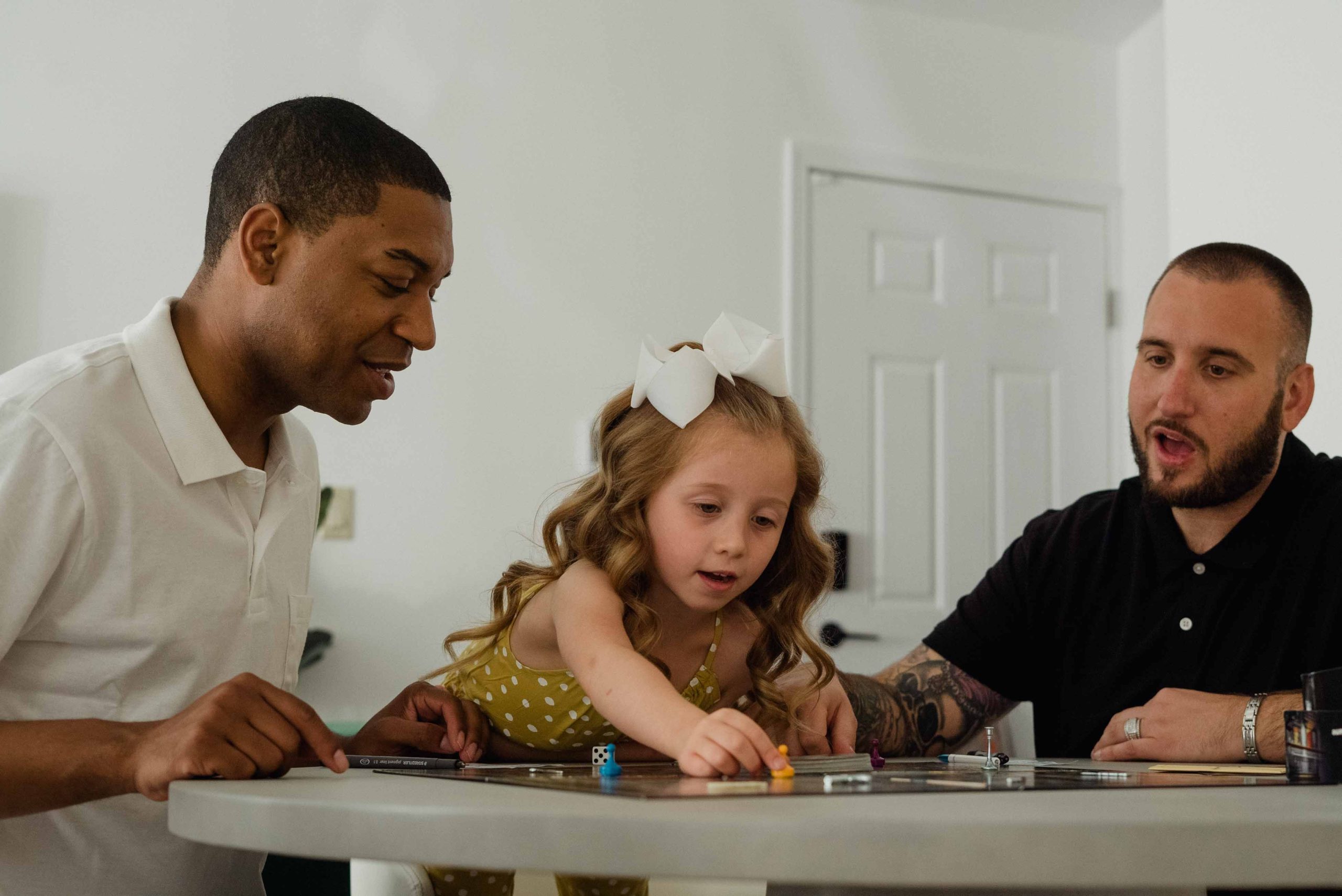 Diverse family and kids gathered around a table enjoying a board game together