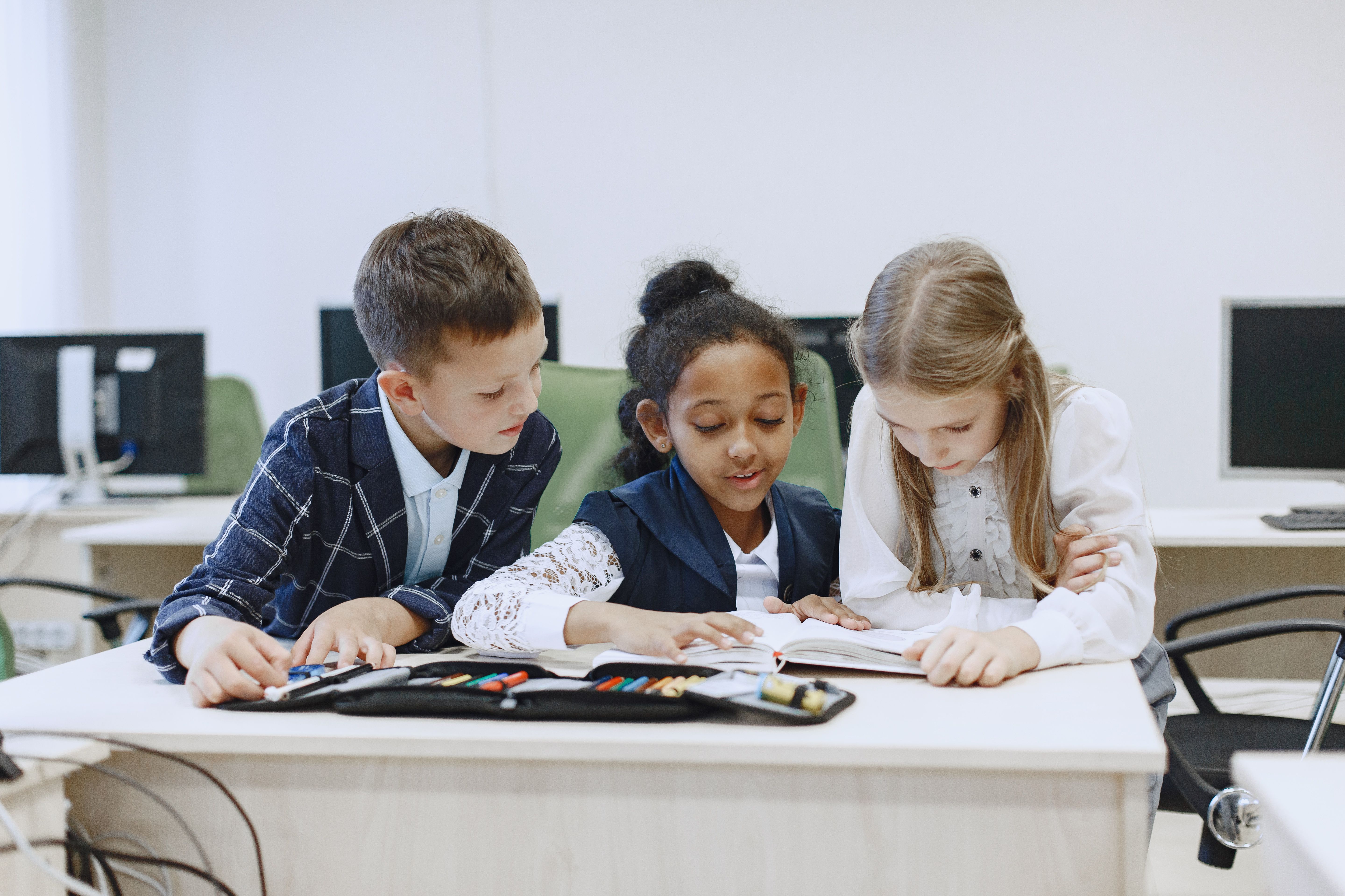 Group of children working together at a table, learning teamwork and justice through collaboration