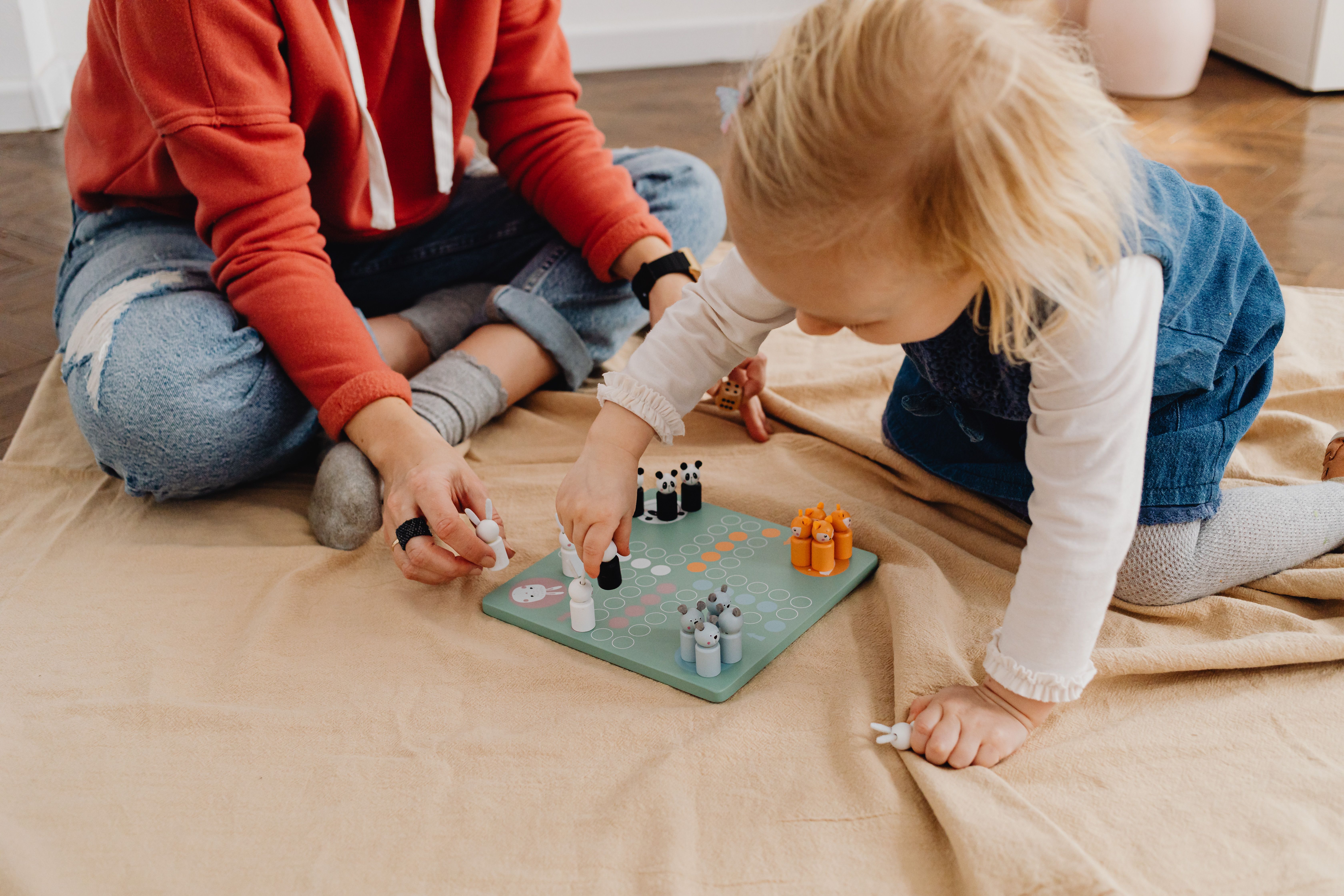 Mother and daughter bonding over a board game, teaching values through play