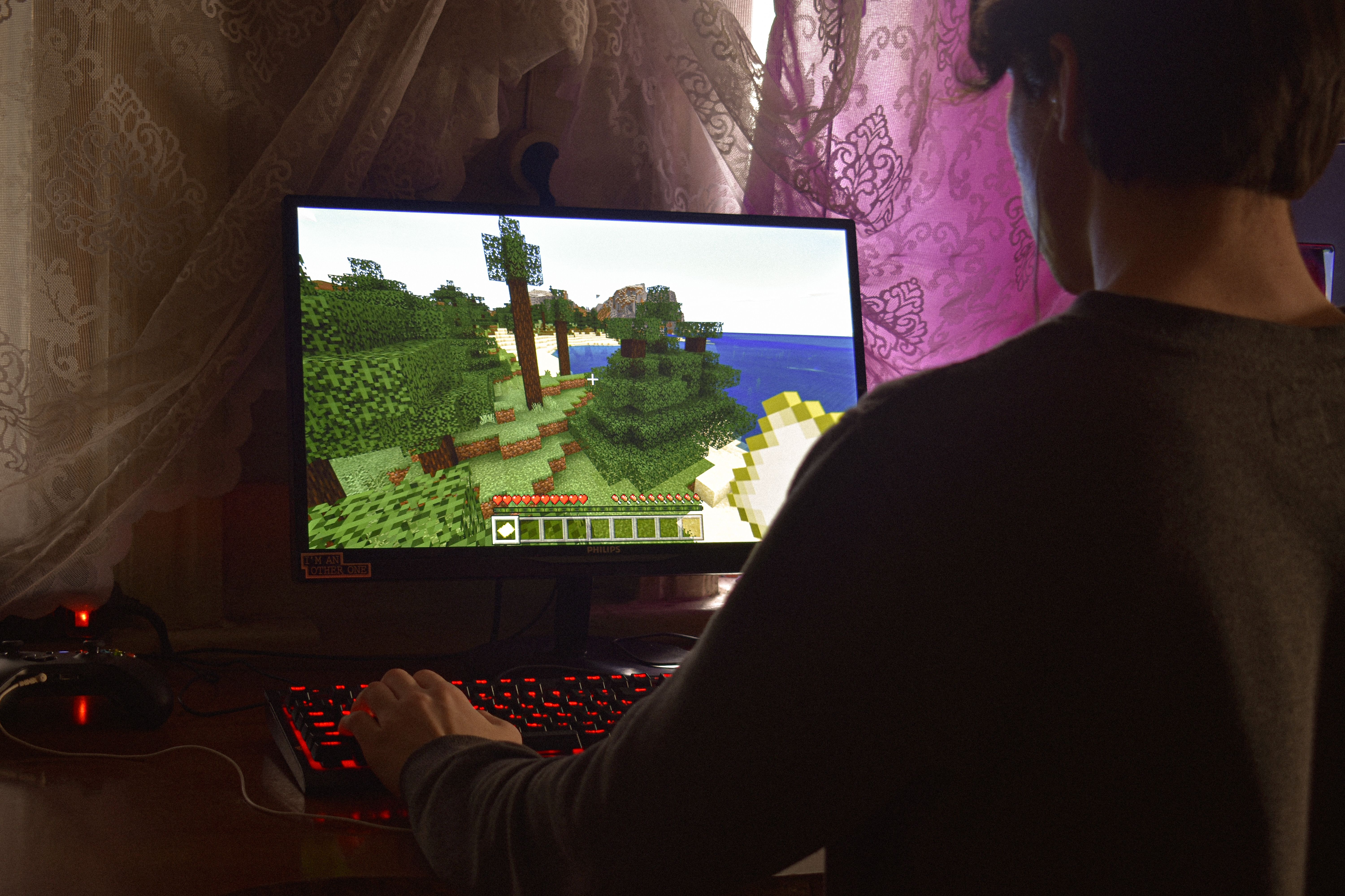 Young man intensely playing a PC video game indoors